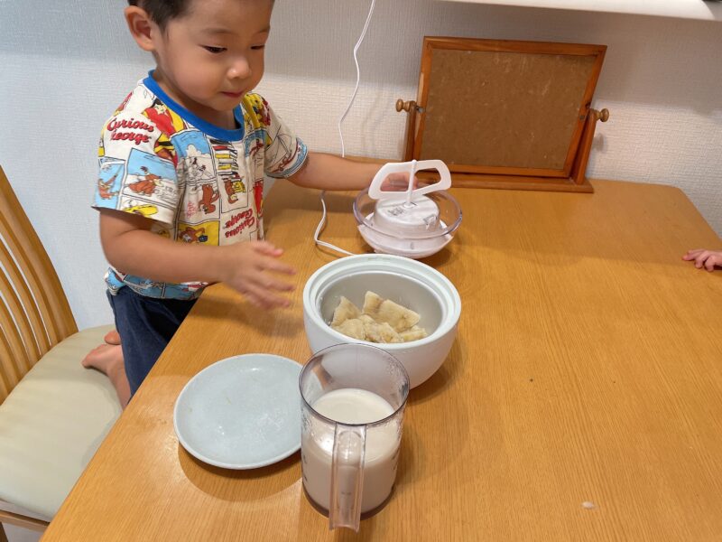 アイスクリームメーカーにバナナを入れる子ども