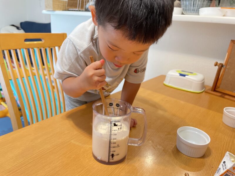 アイスクリームの材料をかき混ぜる子ども