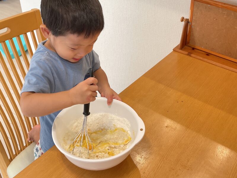 蒸しパンの材料を混ぜる子ども