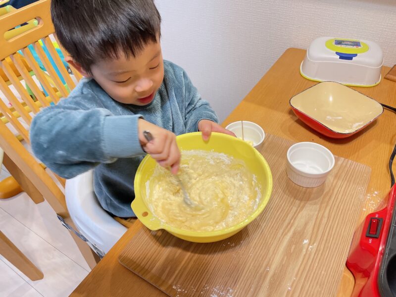 ボウルに入っているホットケーキの材料を混ぜる子ども