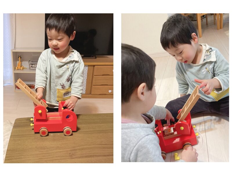 木製の消防車で遊ぶ子ども