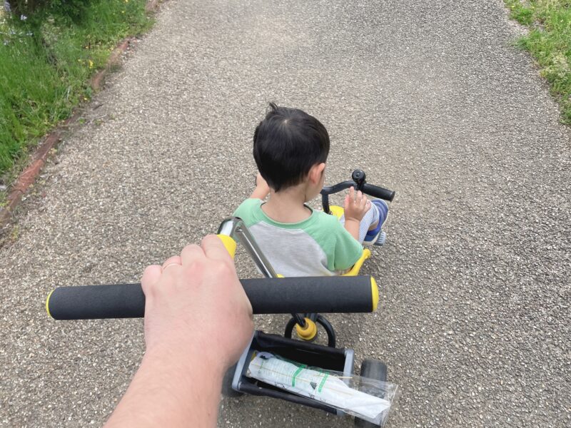 舵取り棒付き三輪車に乗る子ども