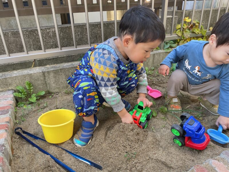 庭の砂場で遊ぶ子ども