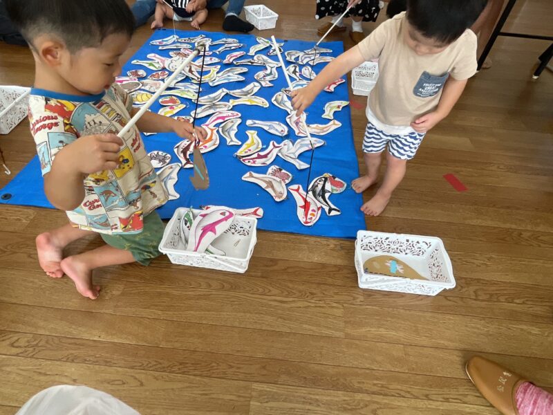 夏まつりのサメつりをする子ども